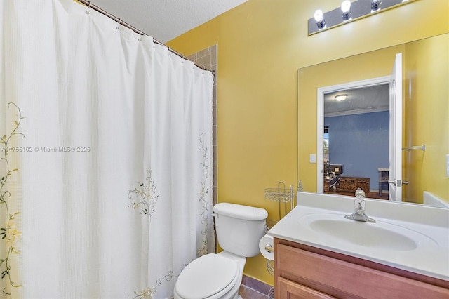 ensuite bathroom with connected bathroom, vanity, toilet, and a textured ceiling