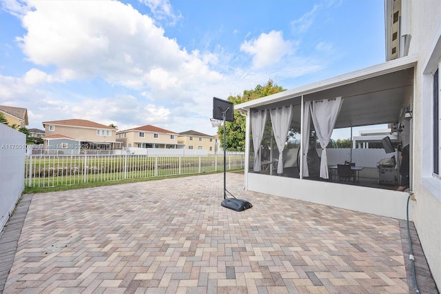 view of patio / terrace with a residential view, a sunroom, and fence