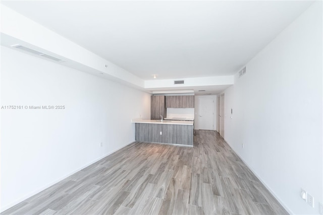 unfurnished living room featuring light wood-type flooring and visible vents