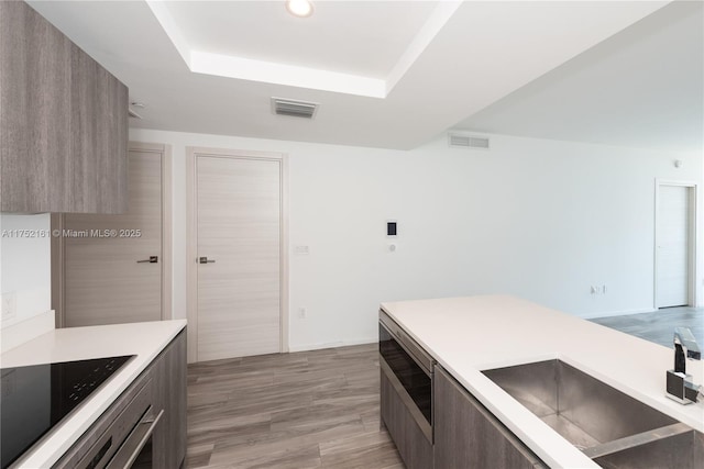 kitchen with light countertops, visible vents, a sink, and modern cabinets