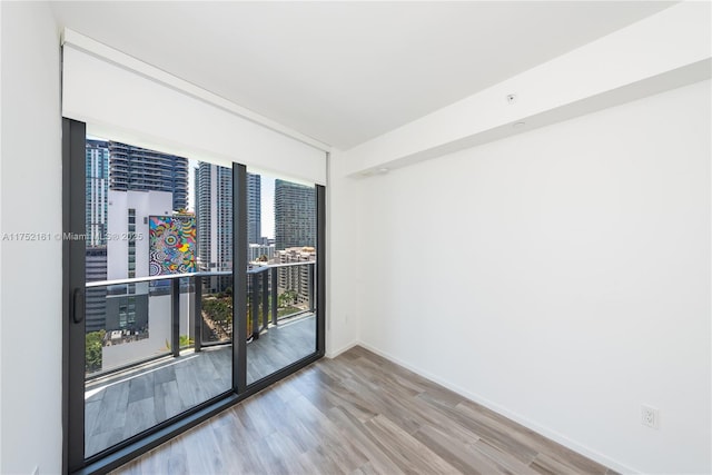 empty room featuring baseboards, a city view, and wood finished floors