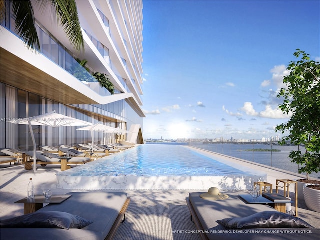 pool with a patio area and a water view