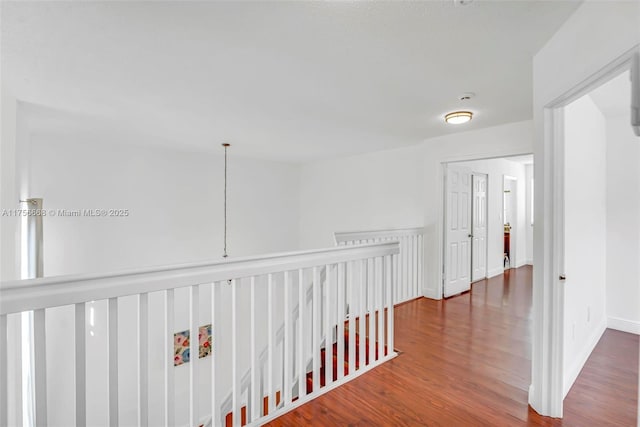 corridor featuring wood finished floors and baseboards