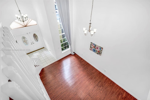 entryway featuring a chandelier, baseboards, and wood finished floors