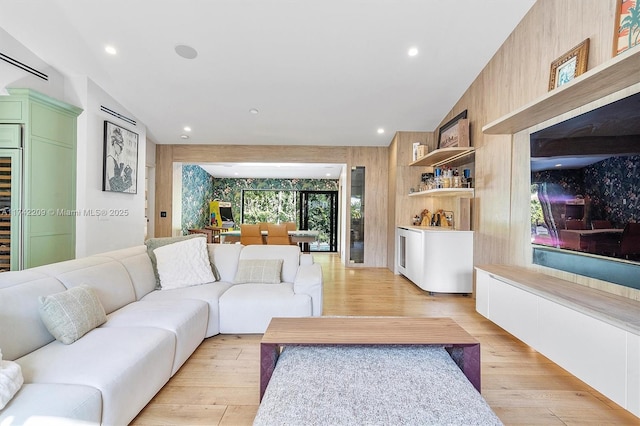 living room with lofted ceiling, light wood finished floors, and recessed lighting