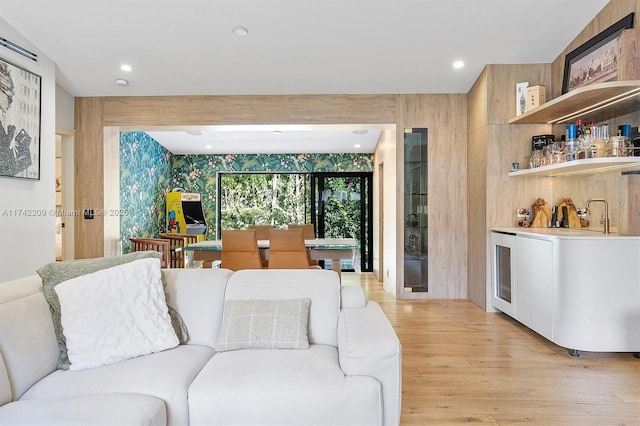 living room featuring recessed lighting, light wood-type flooring, and wet bar