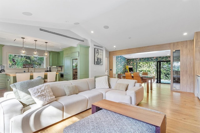 living room with light wood-type flooring, recessed lighting, and lofted ceiling