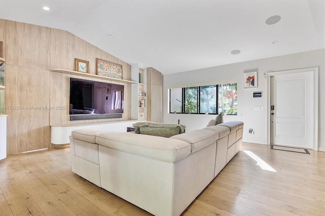 living room featuring lofted ceiling and light wood finished floors