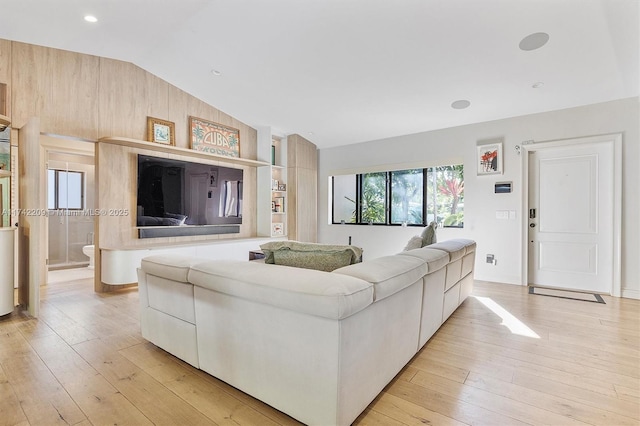 living area with lofted ceiling and light wood-style floors