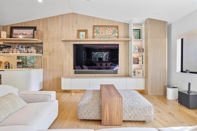 living area with lofted ceiling, hardwood / wood-style flooring, and built in features