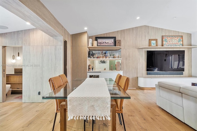 dining area featuring lofted ceiling, wood-type flooring, and recessed lighting