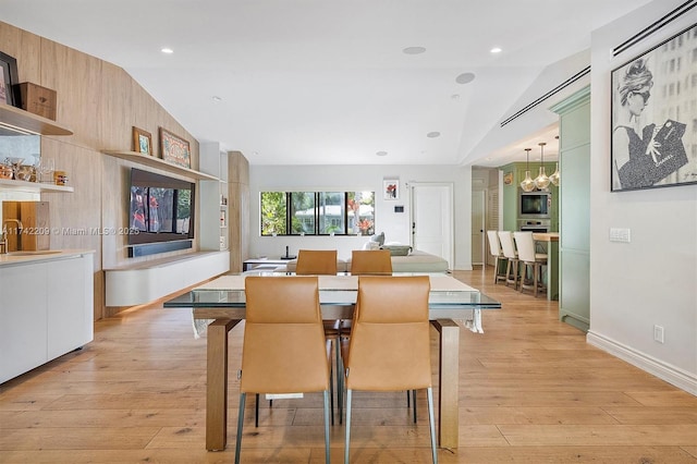 dining room featuring light wood-style floors, recessed lighting, vaulted ceiling, and an inviting chandelier