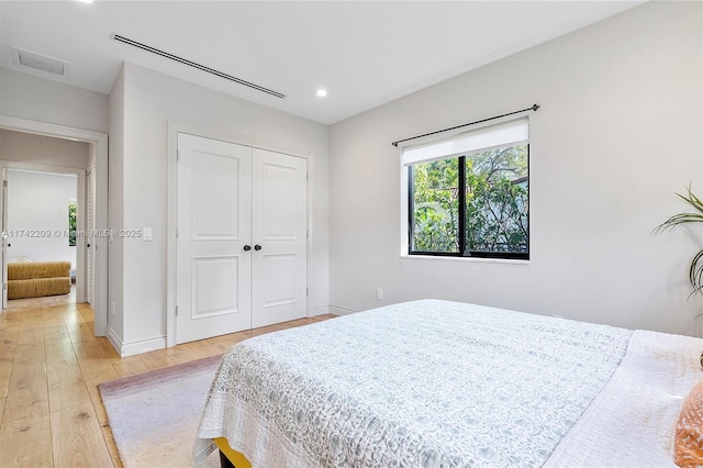 bedroom featuring recessed lighting, a closet, visible vents, light wood-style flooring, and baseboards