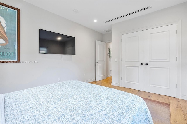 bedroom with recessed lighting, a closet, visible vents, light wood-style flooring, and baseboards