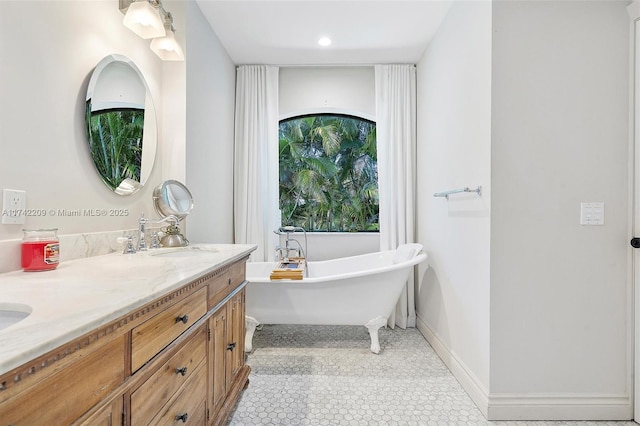 full bathroom featuring tile patterned flooring, a freestanding tub, a sink, baseboards, and double vanity