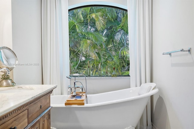 full bathroom with a freestanding tub and vanity