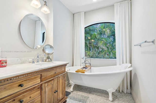 full bath featuring a healthy amount of sunlight, a soaking tub, baseboards, and vanity