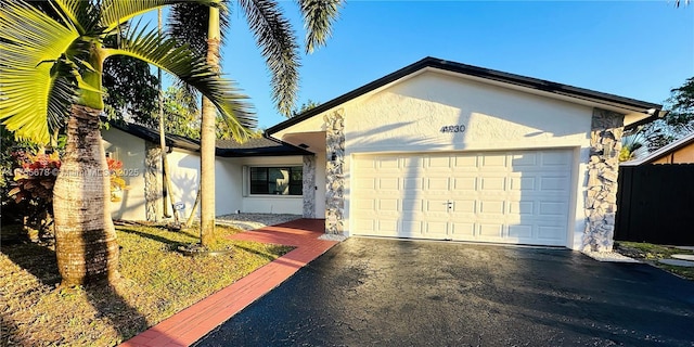 ranch-style house featuring driveway, an attached garage, and stucco siding