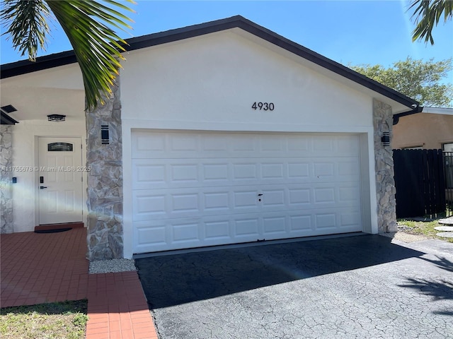 garage with driveway and fence