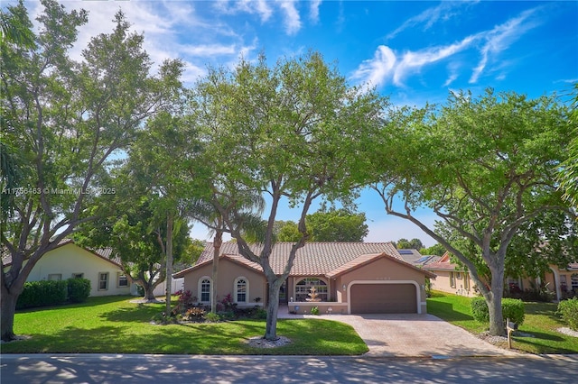 mediterranean / spanish home featuring a garage, a tile roof, decorative driveway, stucco siding, and a front yard