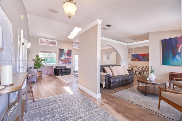 living room with baseboards, visible vents, and wood finished floors