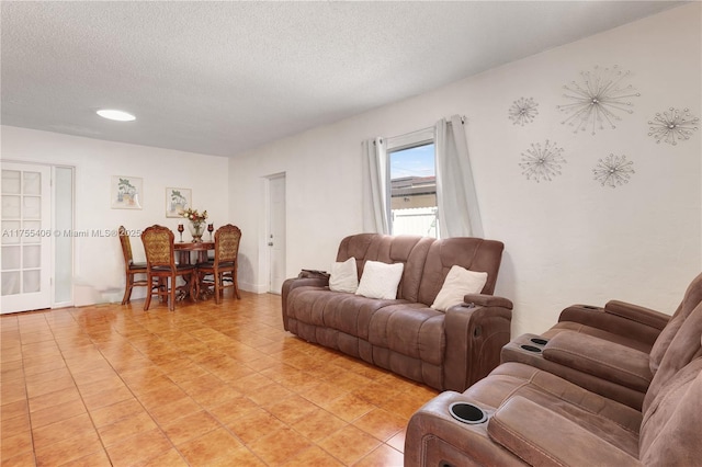 living room featuring a textured ceiling and light tile patterned floors