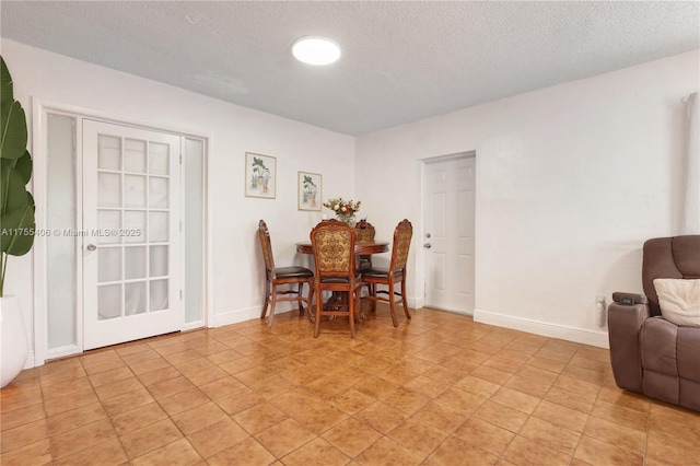 dining room with a textured ceiling and baseboards