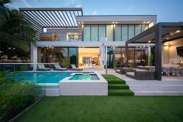 rear view of house featuring a pool with connected hot tub, a patio area, and a lawn