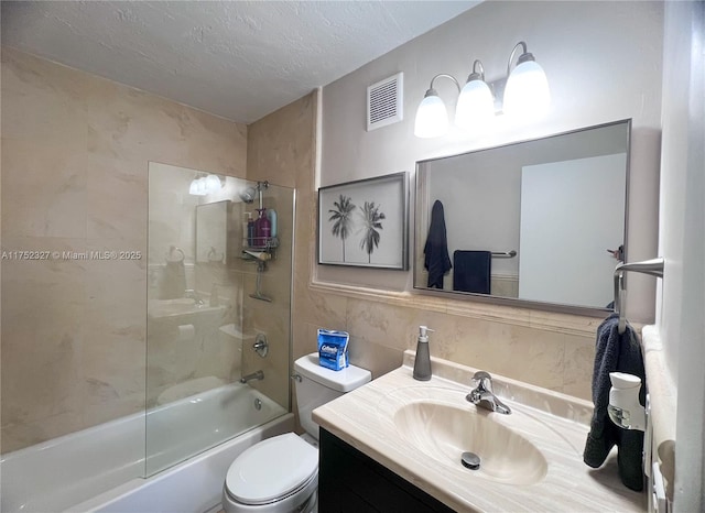 bathroom with visible vents, toilet, combined bath / shower with glass door, a textured ceiling, and vanity