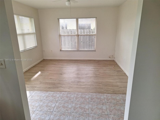 spare room featuring baseboards, a ceiling fan, and tile patterned floors