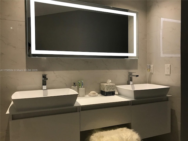bathroom featuring vanity and tile walls