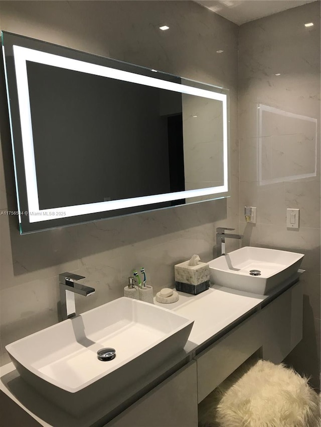 bathroom featuring vanity, tile walls, and tasteful backsplash
