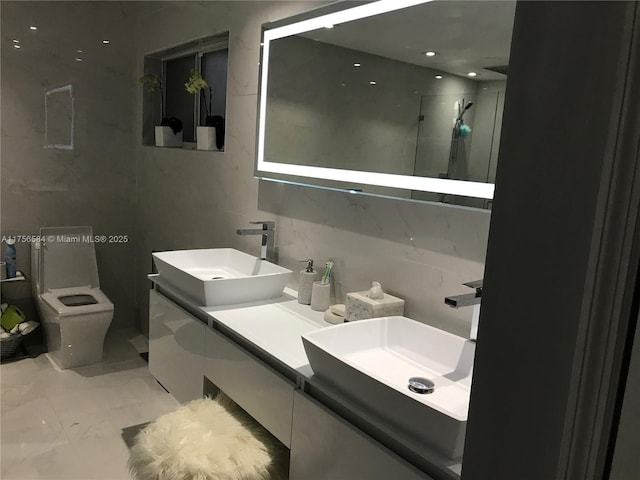 full bath with double vanity, a stall shower, toilet, and a sink