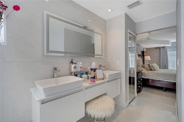 ensuite bathroom featuring double vanity, visible vents, ensuite bathroom, and a sink