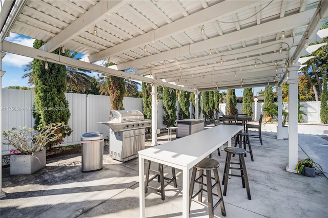 view of patio with grilling area, a fenced backyard, and outdoor dining space
