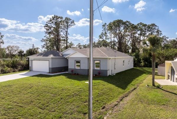 ranch-style home with a garage, concrete driveway, a front lawn, and stucco siding