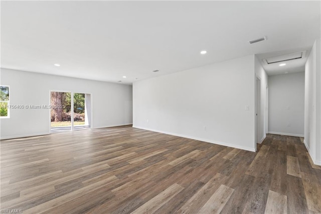 spare room with attic access, baseboards, visible vents, wood finished floors, and recessed lighting