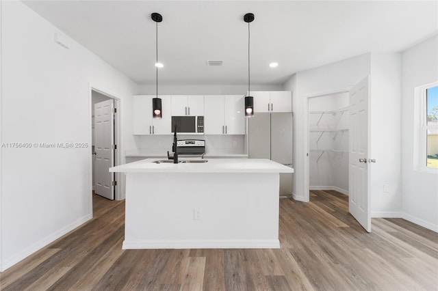 kitchen featuring an island with sink, white cabinetry, light countertops, and a sink