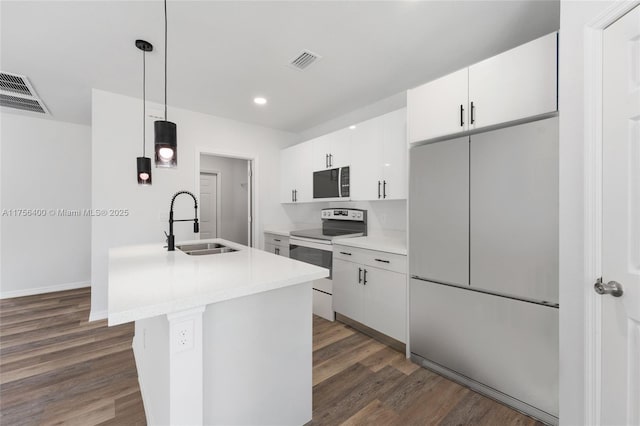 kitchen with a sink, fridge, dark wood finished floors, and electric range oven