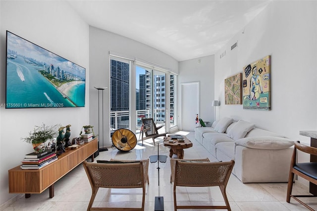 living area with light tile patterned floors, a view of city, and visible vents