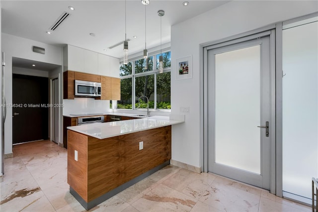 548 Fernwood Rd Unit 548, Key Biscayne, FL 33149 - kitchen featuring a sink, marble finish floor, a peninsula, stainless steel microwave, and visible vents