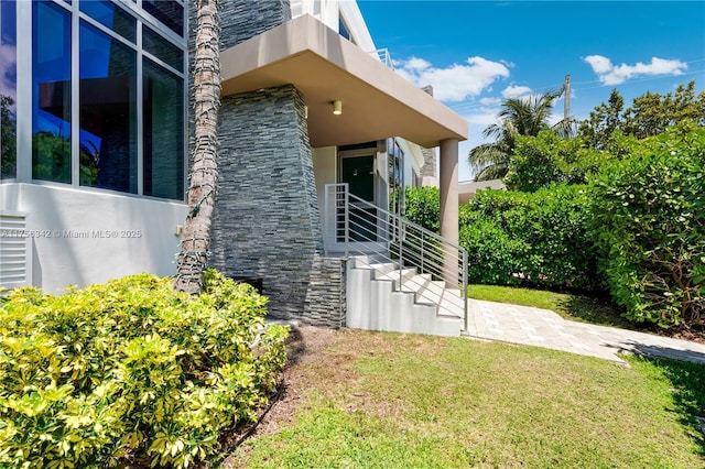 548 Fernwood Rd Unit 548, Key Biscayne, FL 33149 - view of home's exterior featuring a lawn, stucco siding, and stone siding