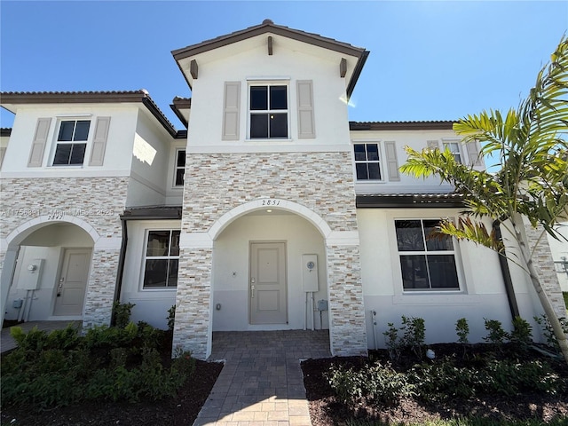 view of front of home with stone siding and stucco siding