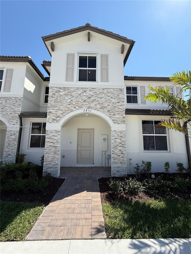 view of front facade with stone siding and stucco siding