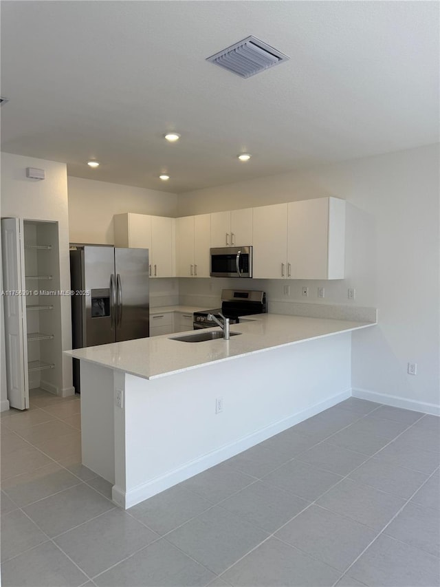 kitchen featuring recessed lighting, stainless steel appliances, a peninsula, visible vents, and light countertops