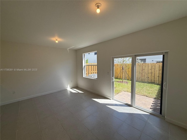 unfurnished room with tile patterned flooring and baseboards