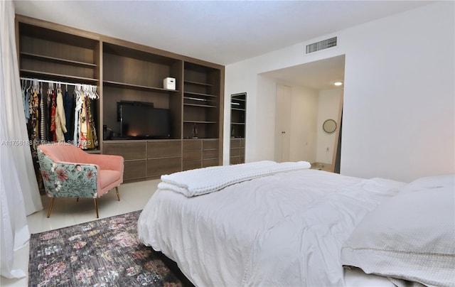 tiled bedroom featuring a closet and visible vents