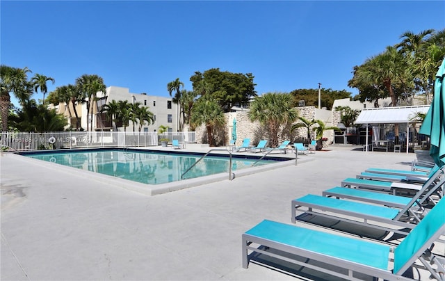 community pool featuring a patio and fence