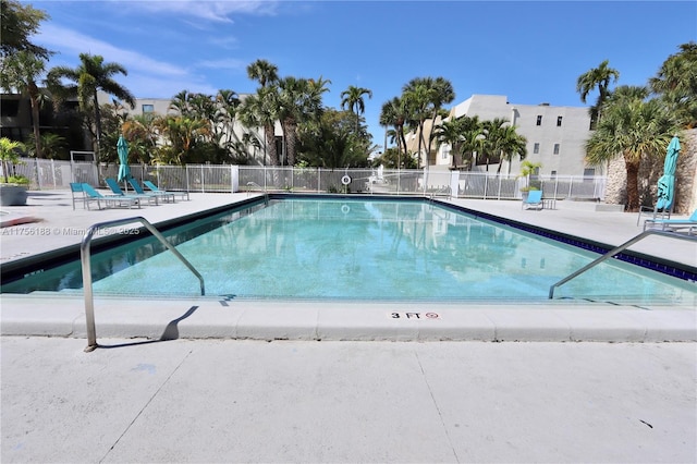 community pool with a patio and fence