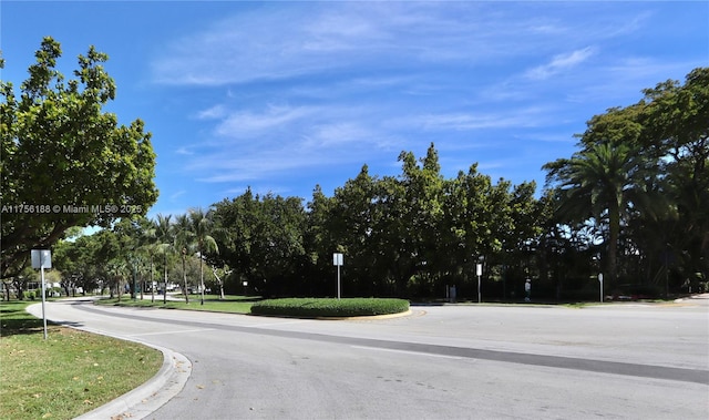 view of road featuring curbs and traffic signs